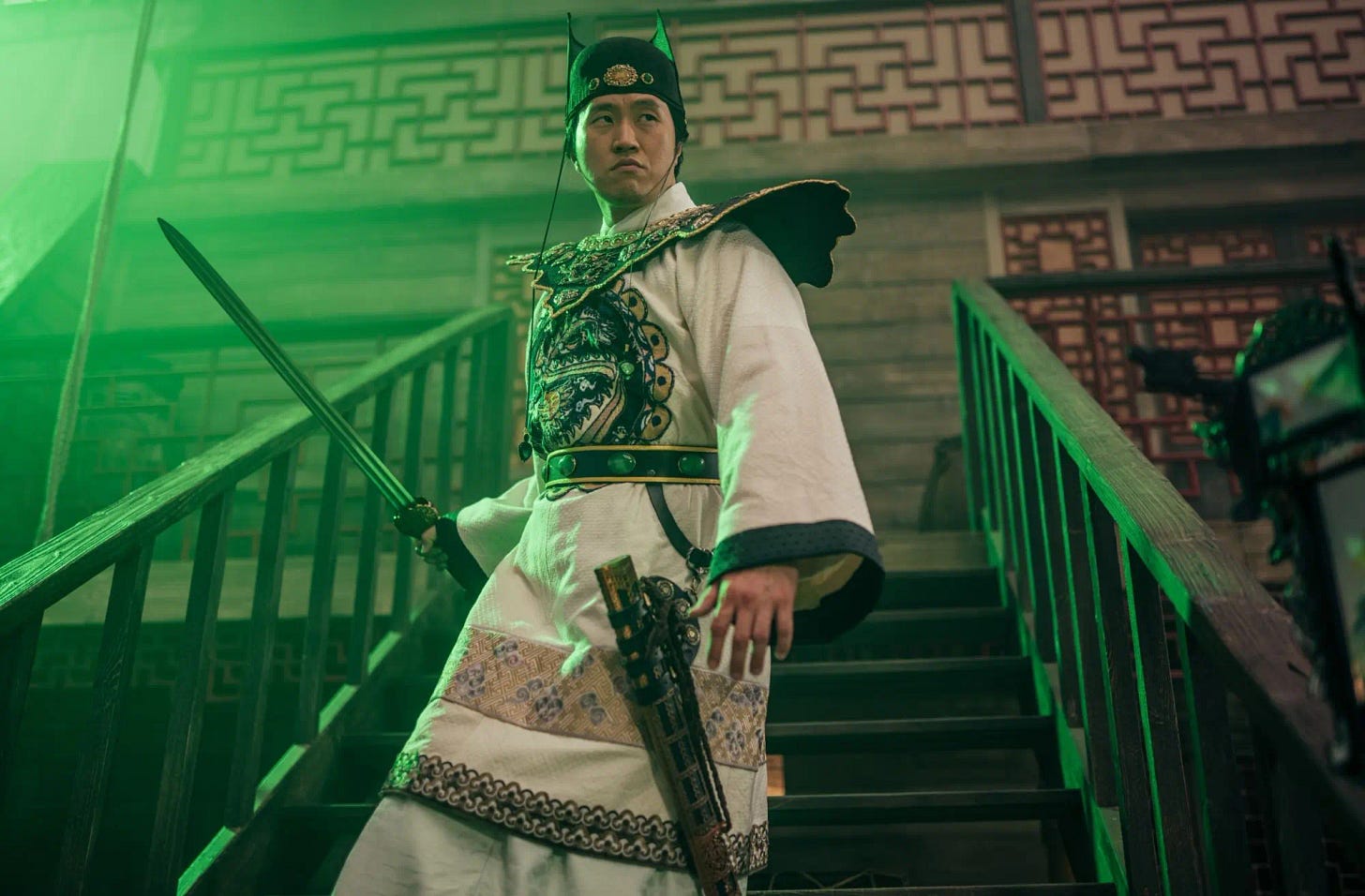 This image shows the character Sin Ji-Hun (played by Arthur Lee), a 16th-Century Chinese pirate, descending a staircase on Madam Ching's 19th-Century pirate vessel while holding his unsheathed sword in his right hand. This image shows the character Sin Ji-Hun (played by Arthur Lee), a 16th-Century Chinese pirate, descending a staircase on Madam Ching's 19th-Century pirate vessel while holding his unsheathed sword in his right hand.