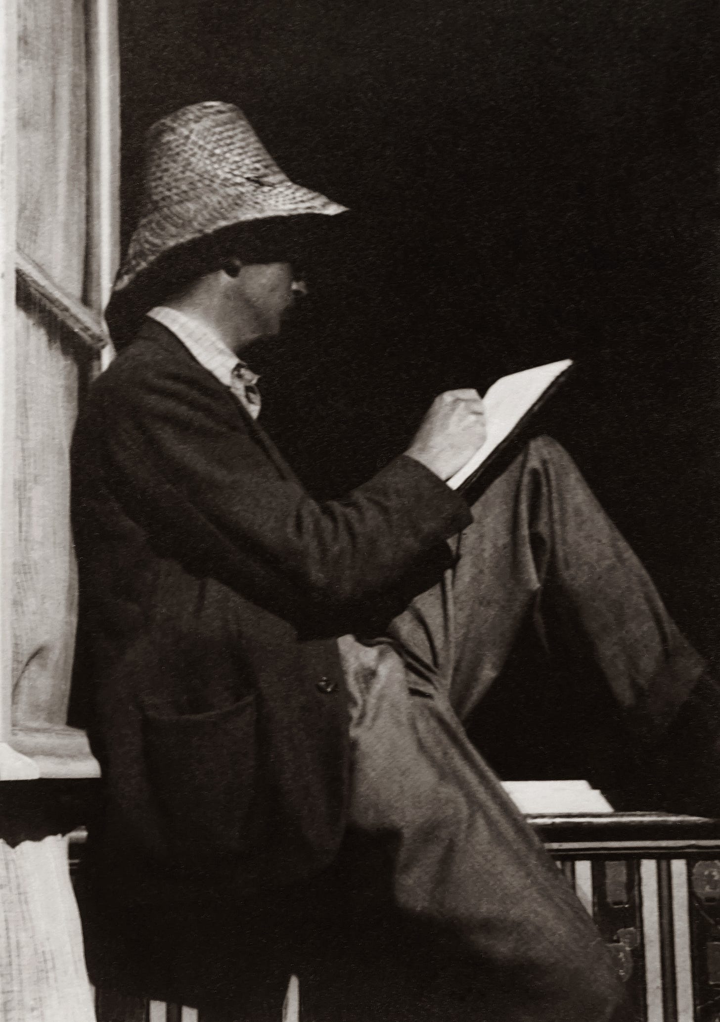 A reader sitting with a book on his lap.