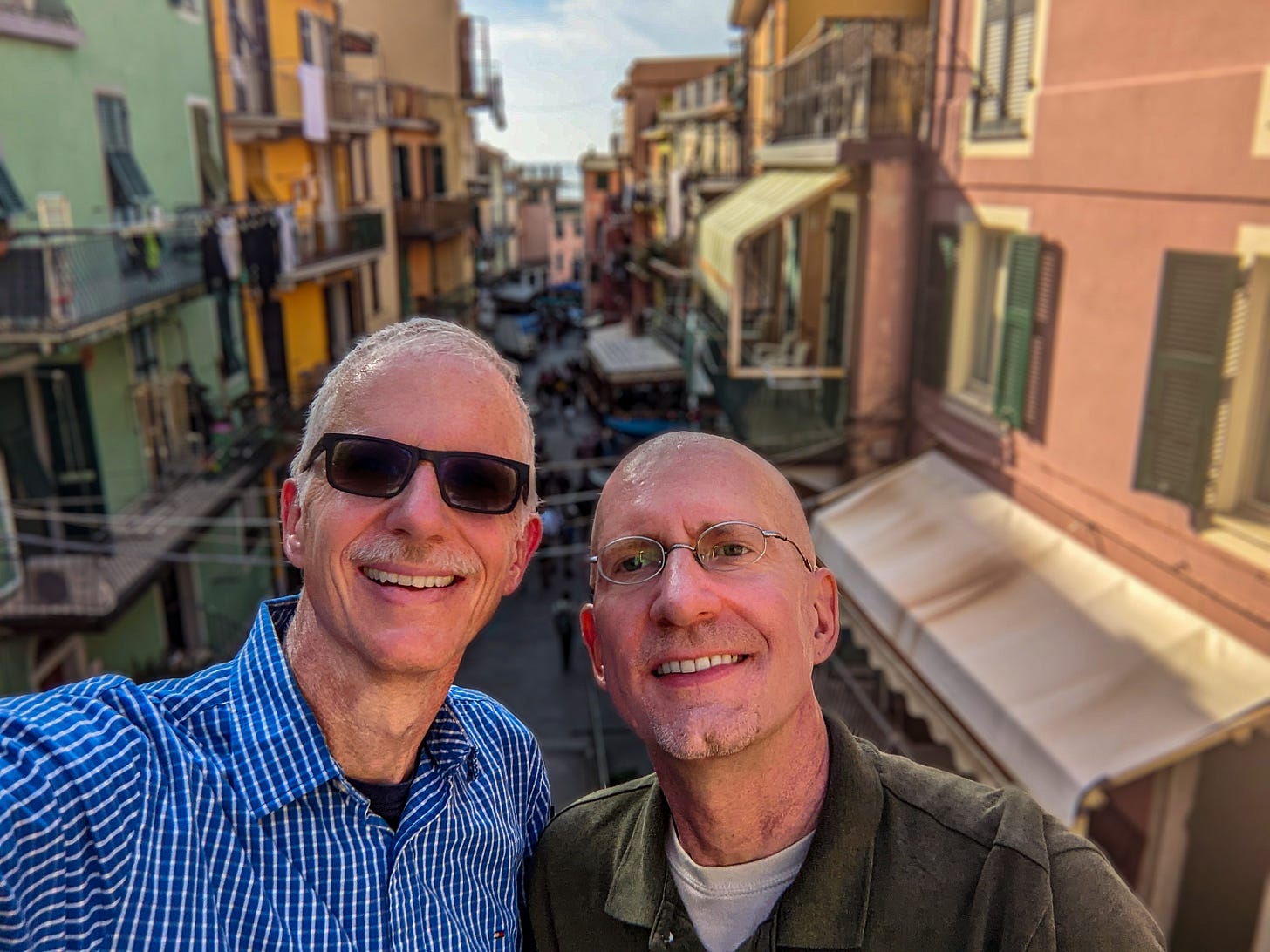Brent and Michael standing in front of the narrow but colorful main street of Manarola. 