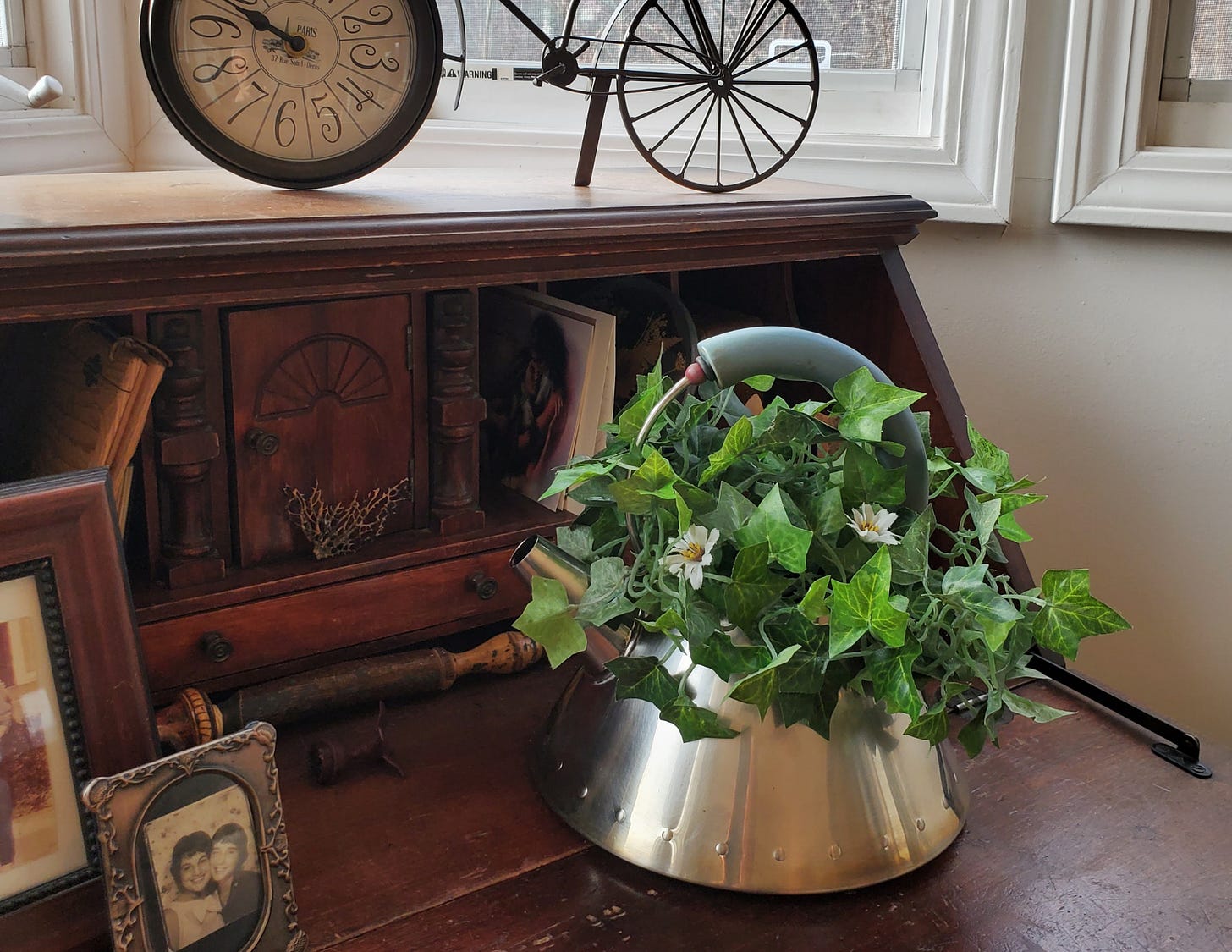 A burned tea kettle repurposed as a flower pot