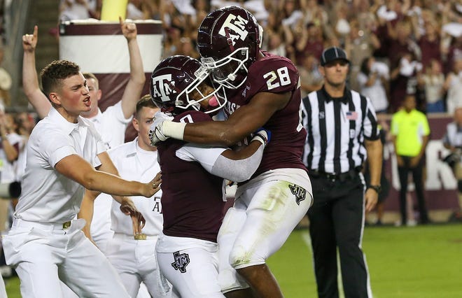Texas A&M receiver Ainias Smith (0) celebrates his touchdown with Isaiah Spiller (28) in the first quarter against Alabama.