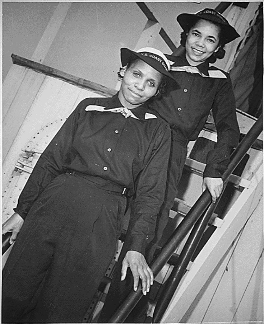 Olivia Hooker is pictured standing on steps aboard USS Commodore. Another Coast Guard woman, Aileen Anita Cooks, stands behind her.