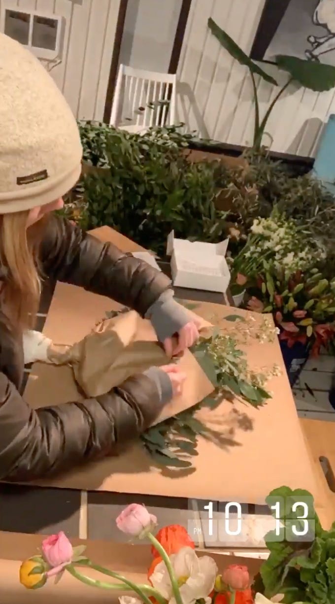 overhead shot of someone wrapping bouquets in kraft paper with 10:13 p.m. time stamp