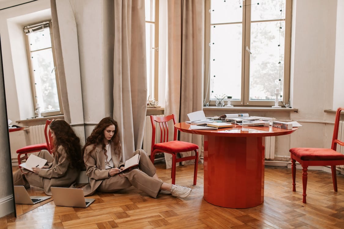 Free Woman Sitting on the Floor While Writing on a Notebook Stock Photo