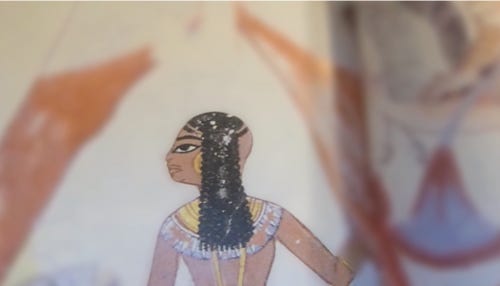 Detail of an ancient egyptian painting. The person’s face and body are in focus, but forearm is blurred.