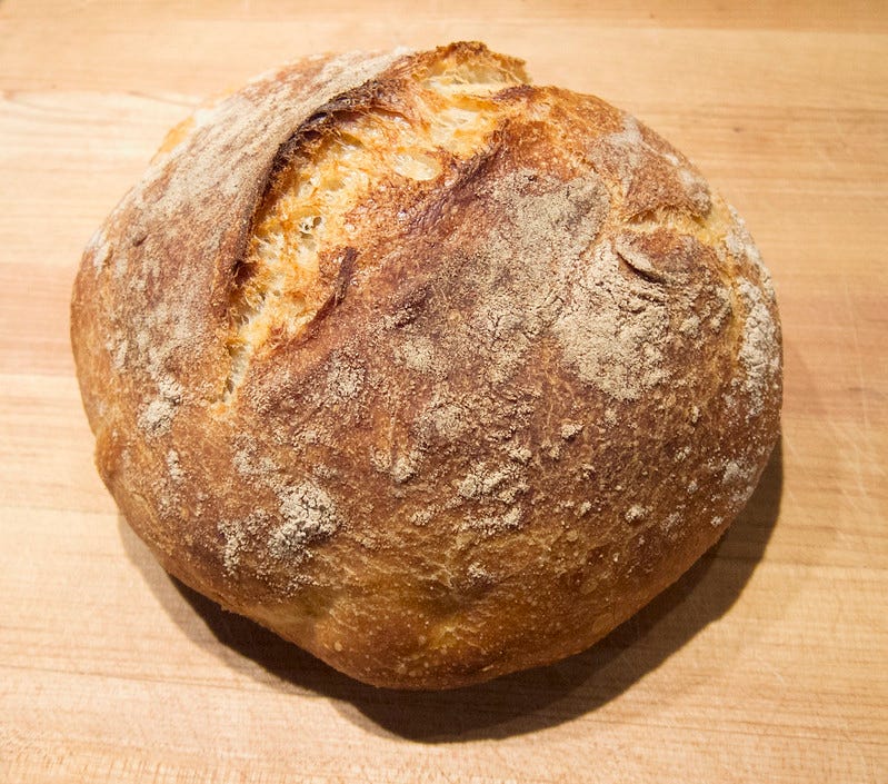 A freshly baked loaf of sourdough bread on a counter.