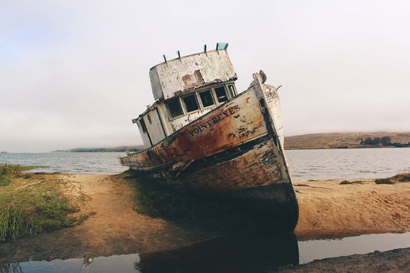 A boat sinking on the sand
