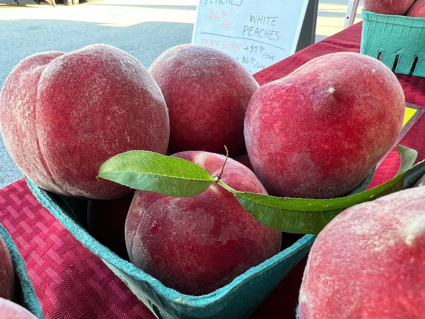 A box of peaches for sale on a table