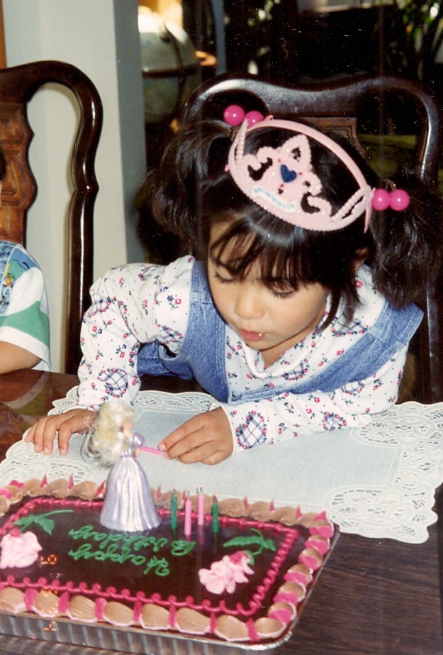 Baby Princess Mia blowing out candles on a Baby Princess birthday cake