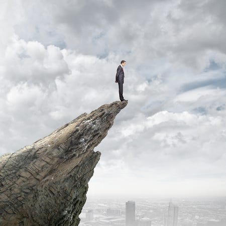 Young businessman standing on edge of rock mountain Stock Photo - 31049397