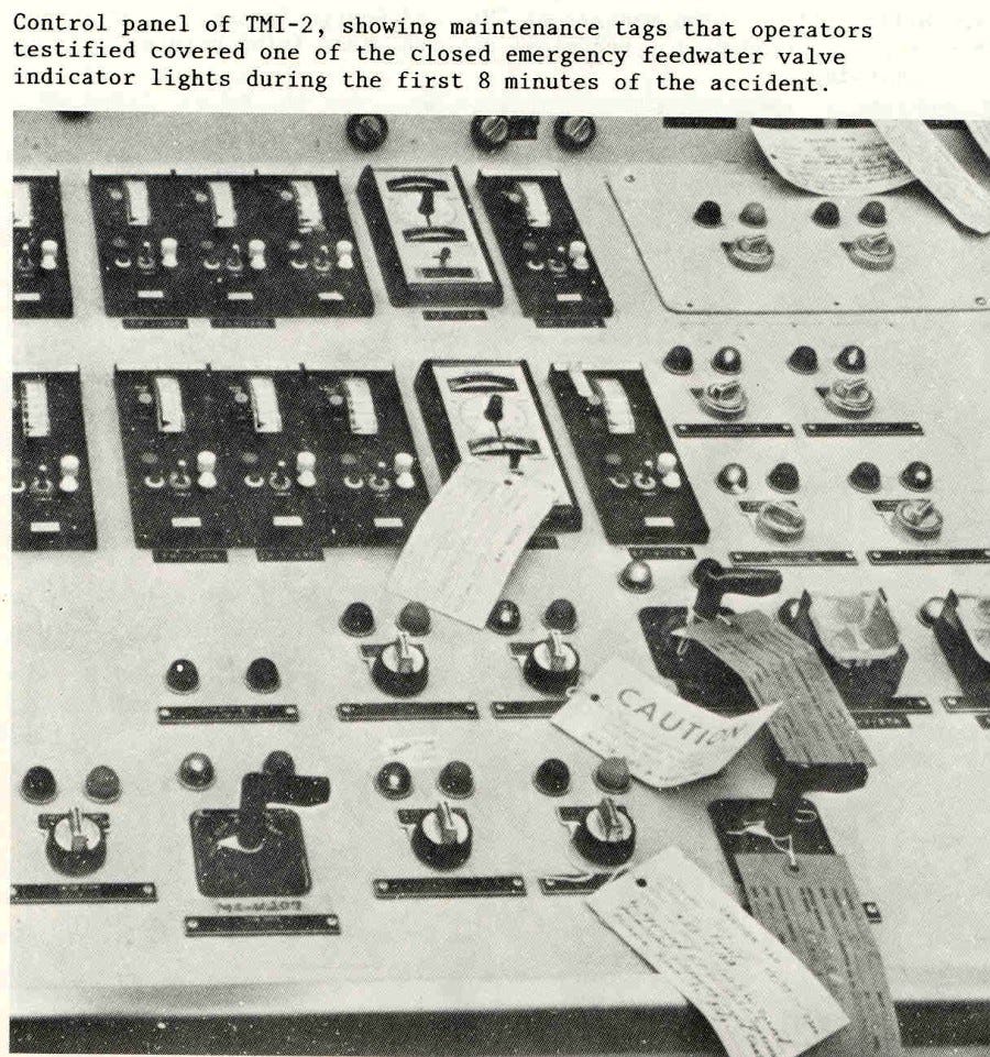 Foto mostra parte do painel de controle da usina nuclear Three Mile Island, nos EUA, com etiquetas sinalizando “Atenção” (Caution) sobre botões e luzes de operação.