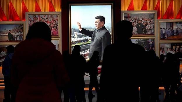 Visitors walk in front of a picture of China’s president Xi Jinping at the Museum of the Communist Party of China in Beijing
