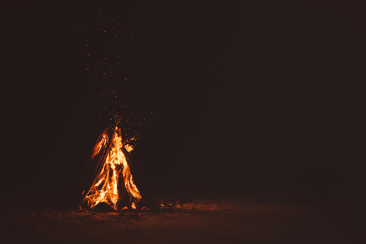 Photo of a small campfire in the dark.