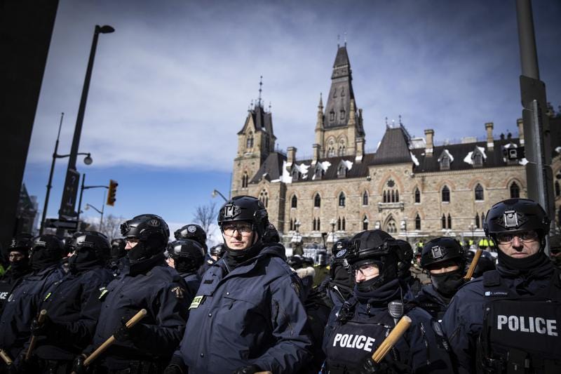 Police block protesters after taking the main street where trucks are parked in Ottawa near Parliament hill  on Saturday, Feb. 19, 2022.  Police resumed pushing back protesters on Saturday after arresting more than 100 and towing away vehicles in Canada’s besieged capital, and scores of trucks left under the pressure, raising authorities’ hopes for an end to the three-week protest against the country’s COVID-19 restrictions.  (AP Photo/Robert Bumsted)