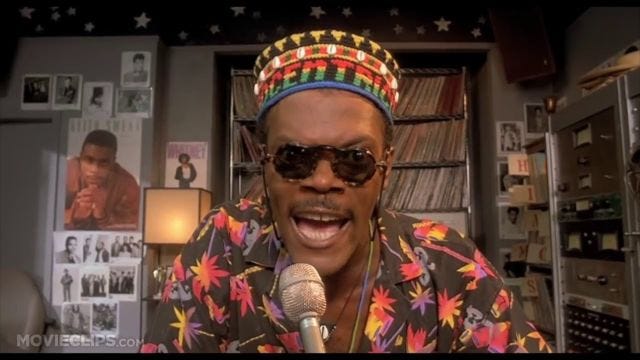 Samuel L. Jackson, a Black man wearing a knit cap that reads "Afrocentric" and a dark tropical print button-down, portrays his character Senor Love Daddy in the Spike Lee movie 'Do the Right Thing'