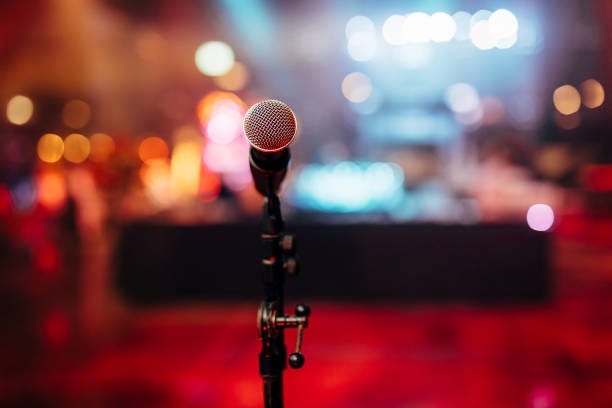 MIC ON A STAGE READY FOR THE SINGER OR SPEAKER MIC ON A STAGE READY FOR THE SINGER OR SPEAKER WITH BLURRED BCKGROUND AND COLOUR BACK. stand up comedy stock pictures, royalty-free photos & images