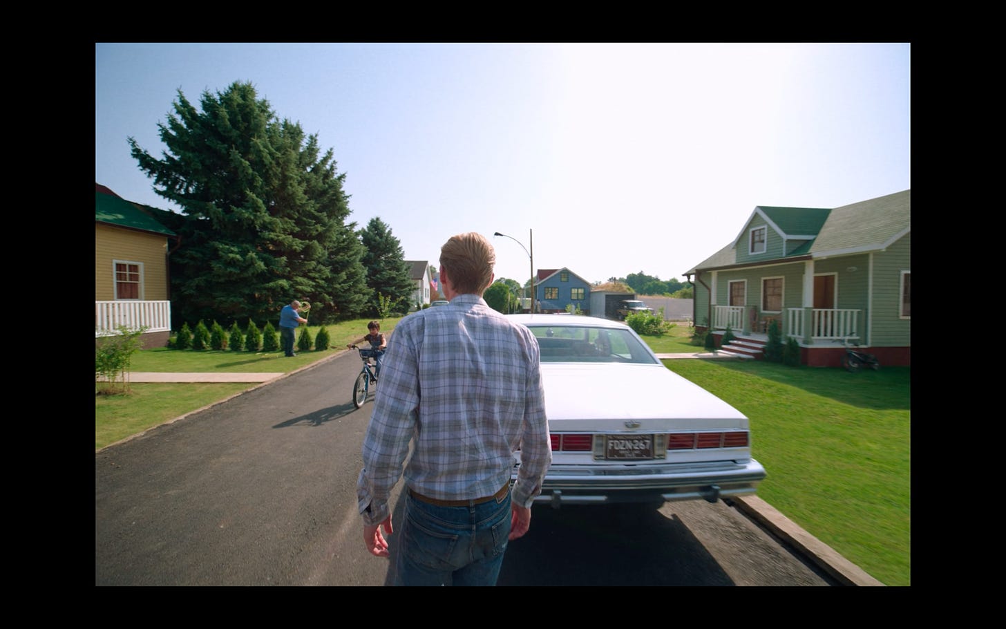 A picture of Frank, the film's secondary antagonist, walking down an idyllic suburban street in the 1980s