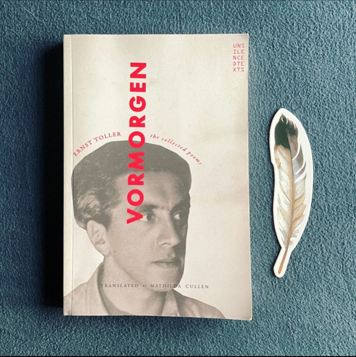 A photograph of the cover of VORMORGEN, which features a photograph of Ernst Toller. A paper feather lays beside it on a solid background.