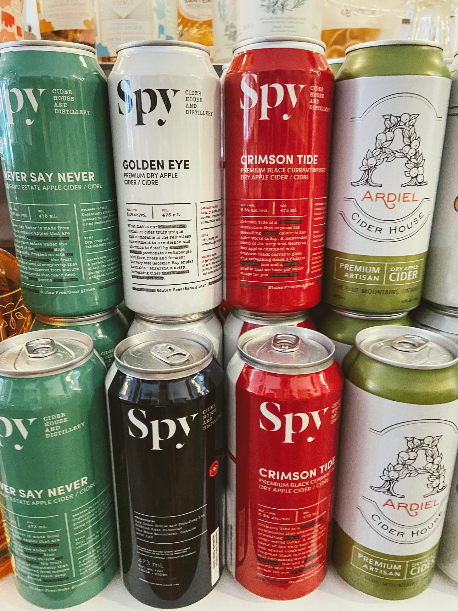 Cans of apple cider, mostly from Spy Cider House
