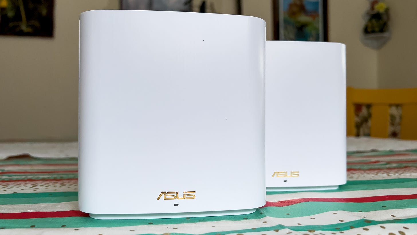 An Asus ZenWiFi XD6 and satellite sitting on a table