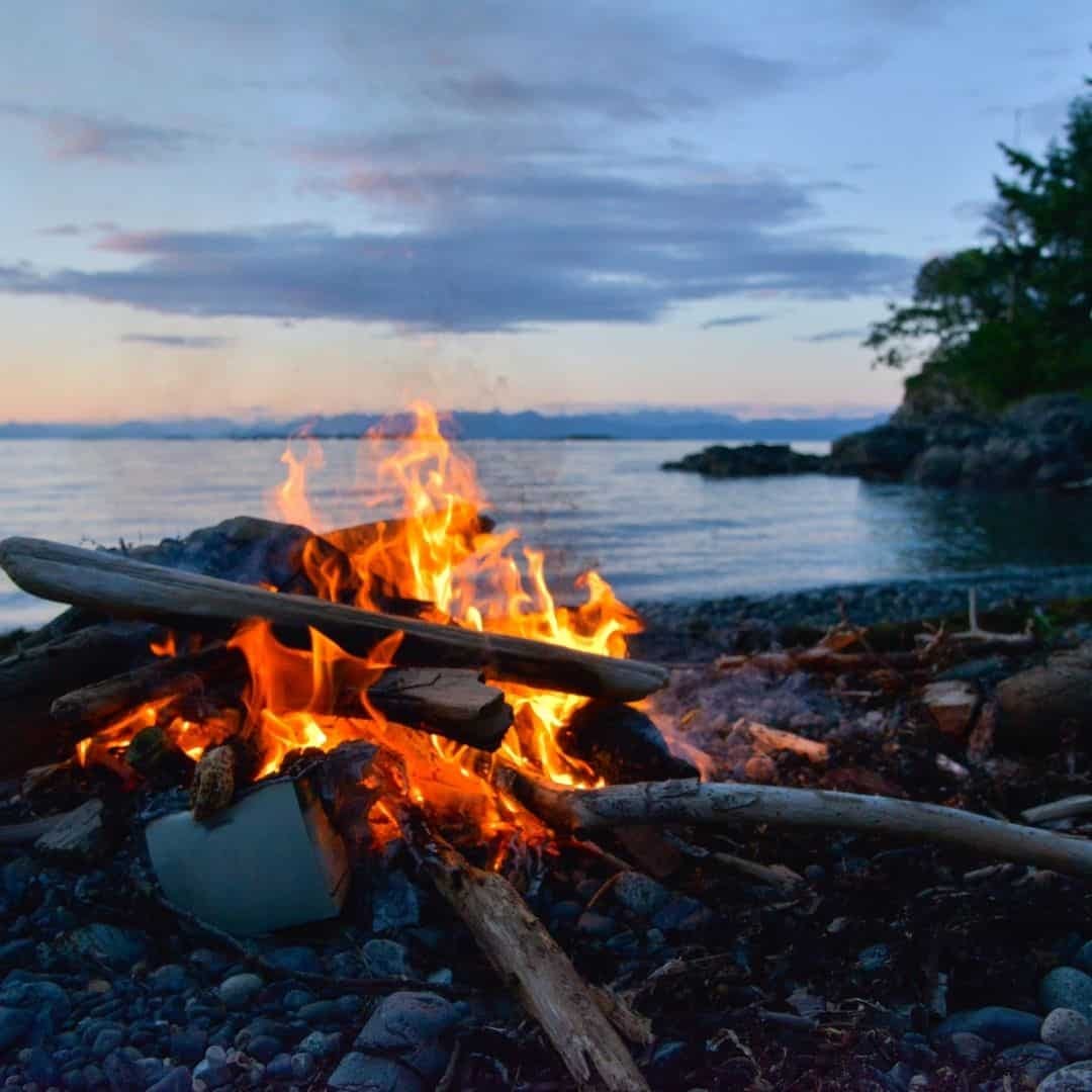 Campfire at the beach on a lake at sunset