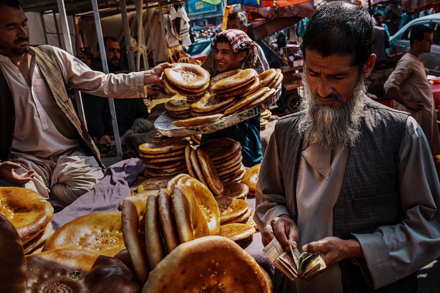 A man counting his Afghan currency before paying for bread