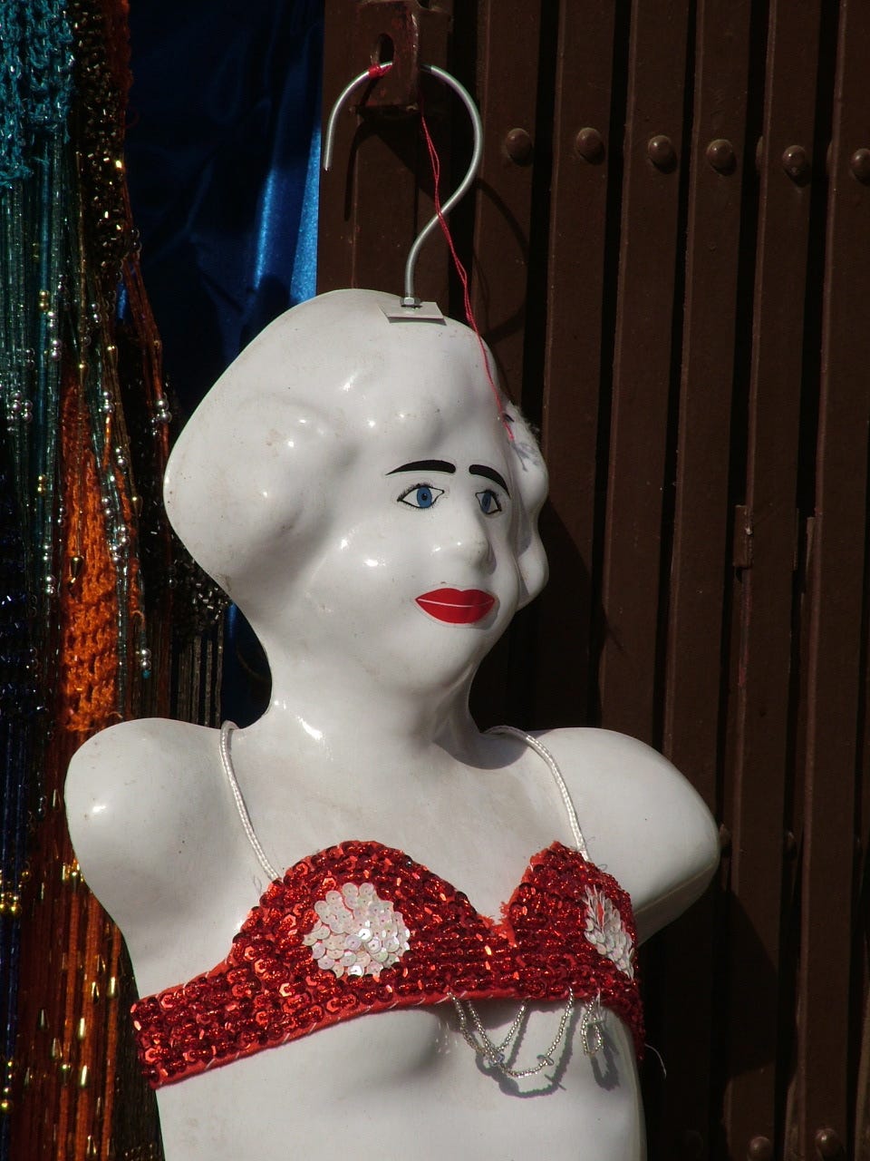 mannequin of a female figure in a bikini top hanging at a market stall in Cairo
