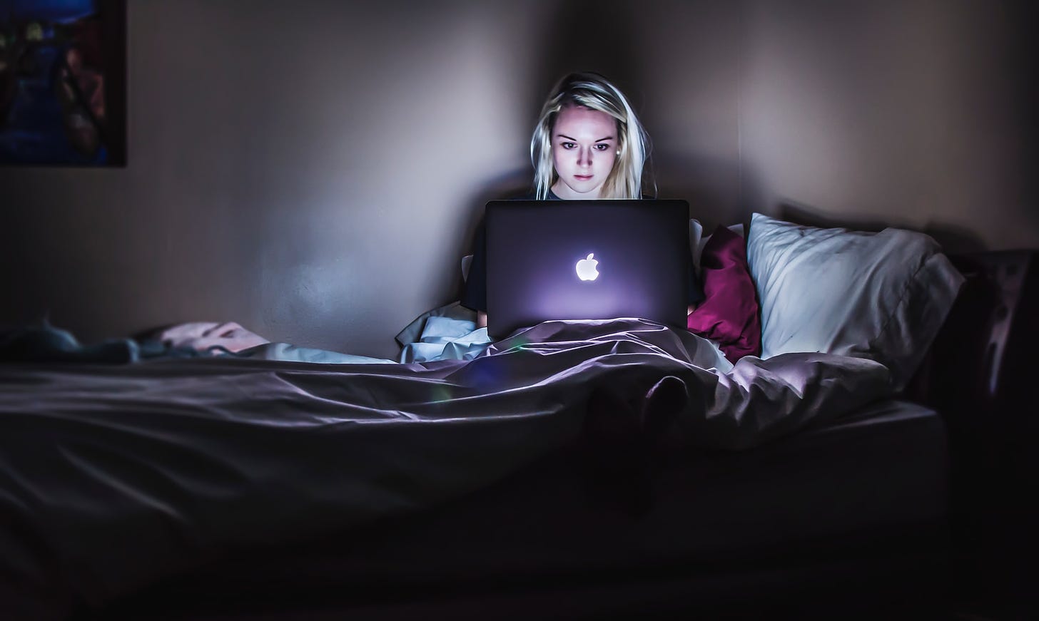 young woman applying to unemployment online late at night
