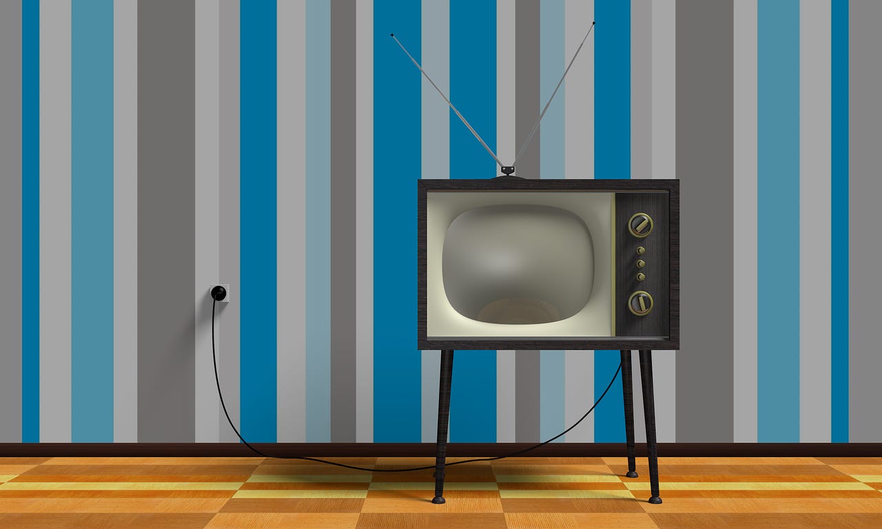 1960's TV with rabbit ear antenna against wall with striped wallpaper. Good example of disruption.