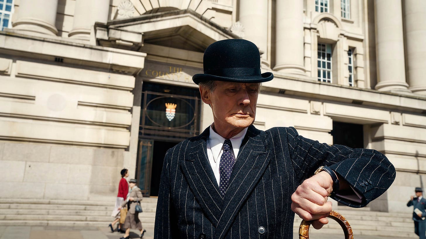 Bill Nighy checking his watch in a still from Living