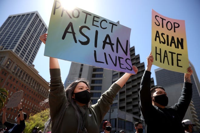 Demonstrators hold signs during a rally to show solidarity with Asian Americans at Embarcadero Plaza on March 26, 2021, in San Francisco.