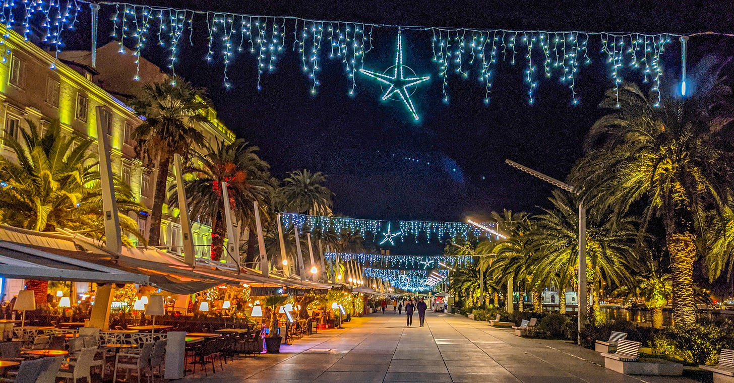 Blue icicle Christmas lights and stars hang over Split's Riva. 