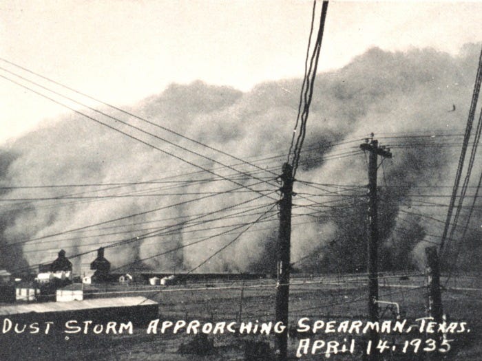 Dust storm approaching Spearman, Texas (April 14, 1935).  The dust looks like a huge dense cloud rolling forward across the ground.