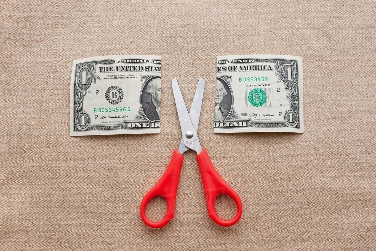 One dollar bill cut in half with scissors - Stock Photo - Dissolve