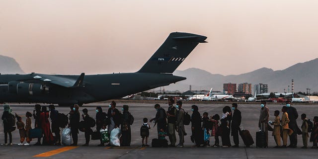 Evacuees wait to board a Boeing C-17 Globemaster III during an evacuation at Hamid Karzai International Airport in Kabul, Afghanistan, on Aug. 23, 2021. 