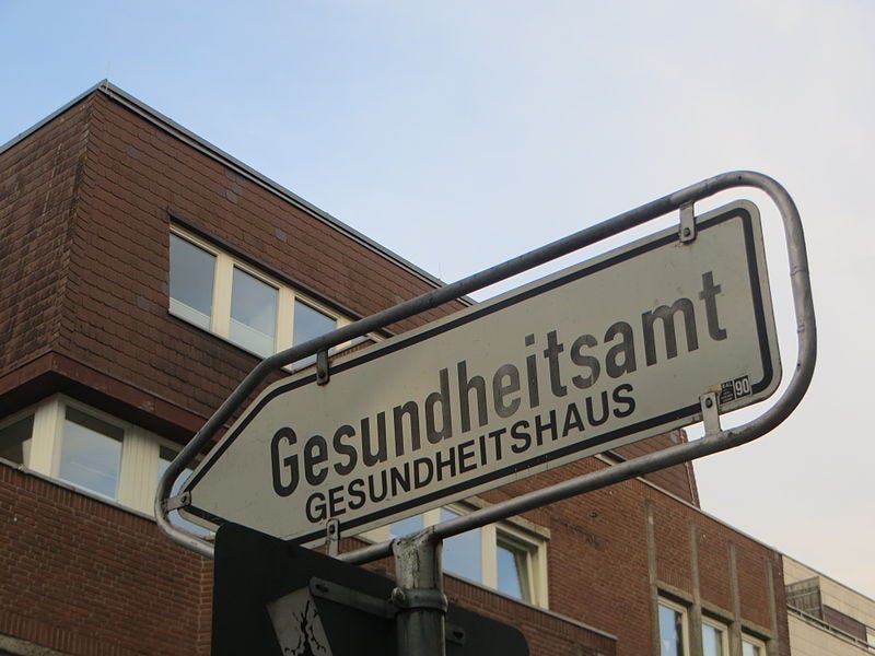 File:Hinweisschild Gestundheitsamt mit dem Gesundheitsamt dahinter (Flensburg), Bild 01.JPG