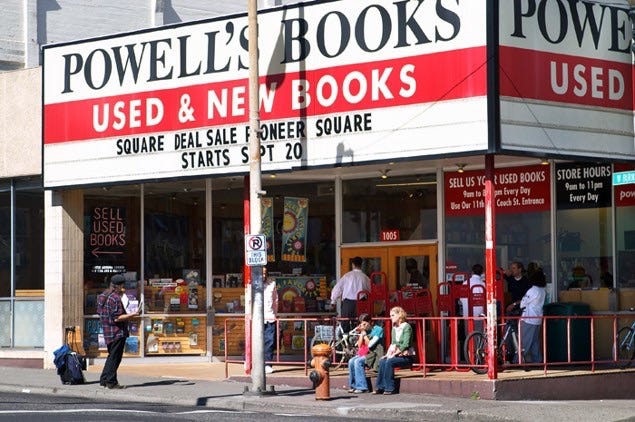 A 2002 photo of the outside of Powell's Books with Laura sitting outside in a green sweater. 