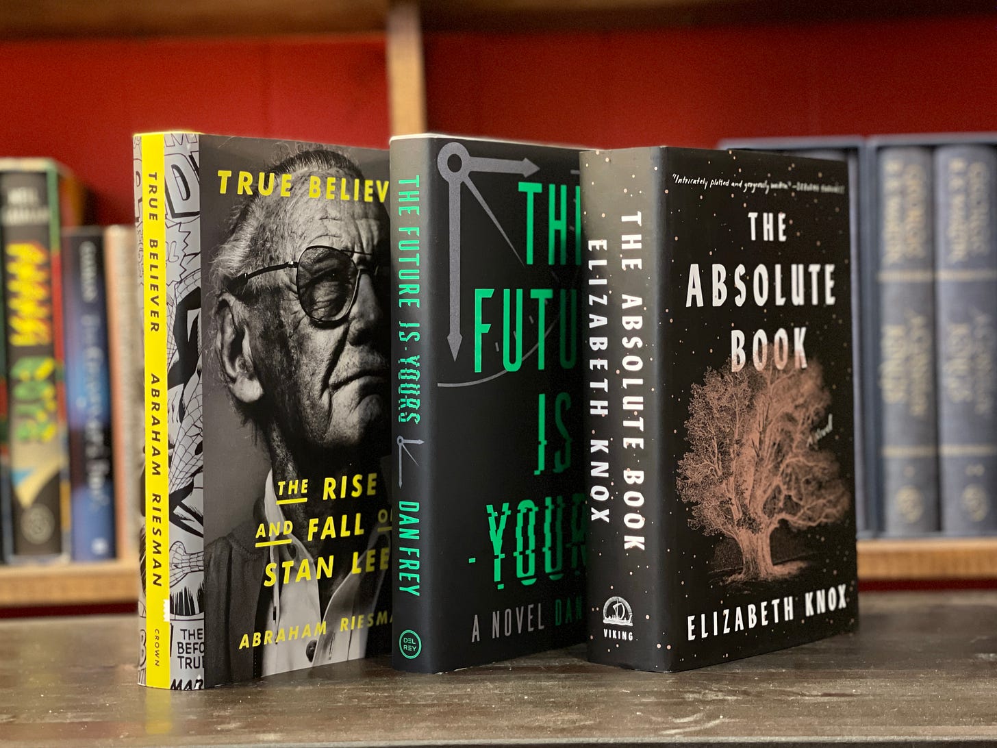 Three books stand up on a table: True Believer, The Future is Yours, and The Absolute Book