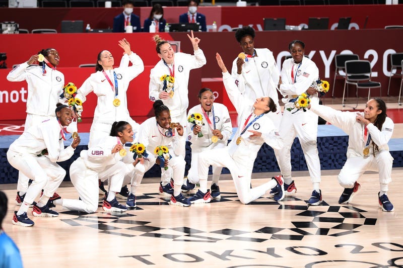 USA Basketball poses with their gold medals after beating Team Japan at the Tokyo Olympics.