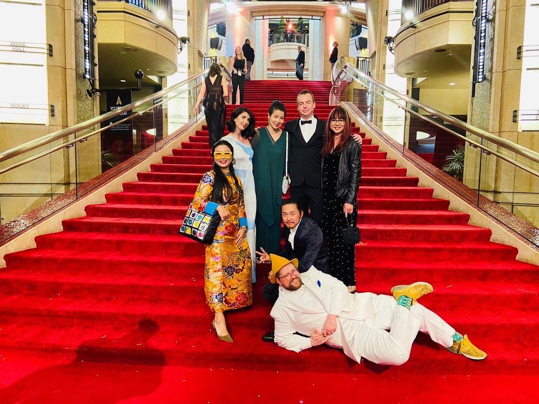 A photo of Ana with Ascension's core production team on the red carpet stairs leading to the Dolby Theater