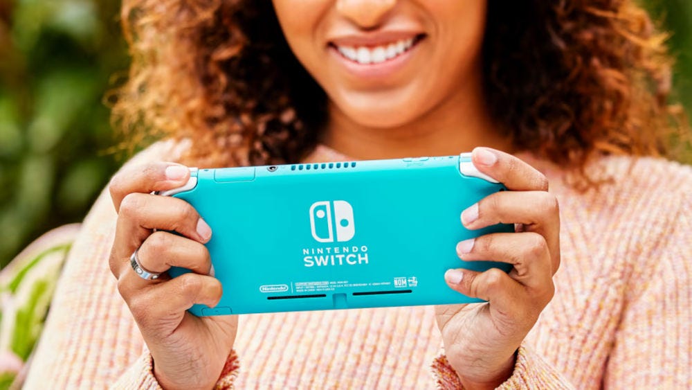 A woman holding a Nintendo Switch Lite