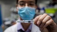 ans un laboratoire du nord de Pékin, un homme en blouse blanche exhibe l'un des tout premiers vaccins expérimentaux contre le nouveau coronavirus. 
