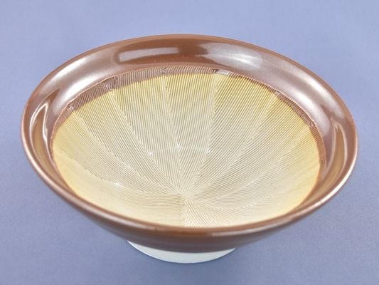 A ceramic bowl with grooves etched into the side for grinding sesame seeds