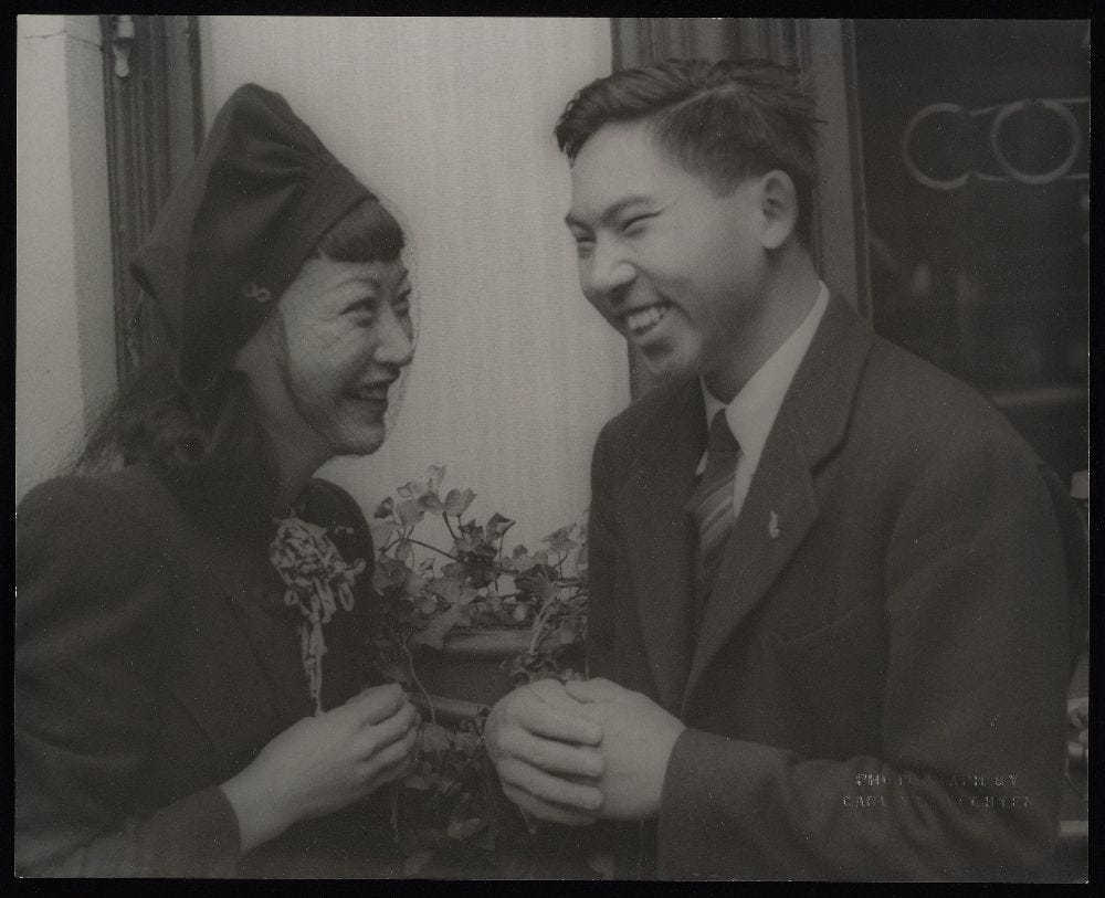 black and white photo of AMW and Richard Wong smiling ad each other