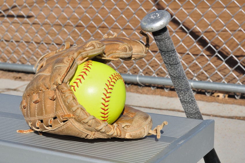 Softball bat and glove on a bench