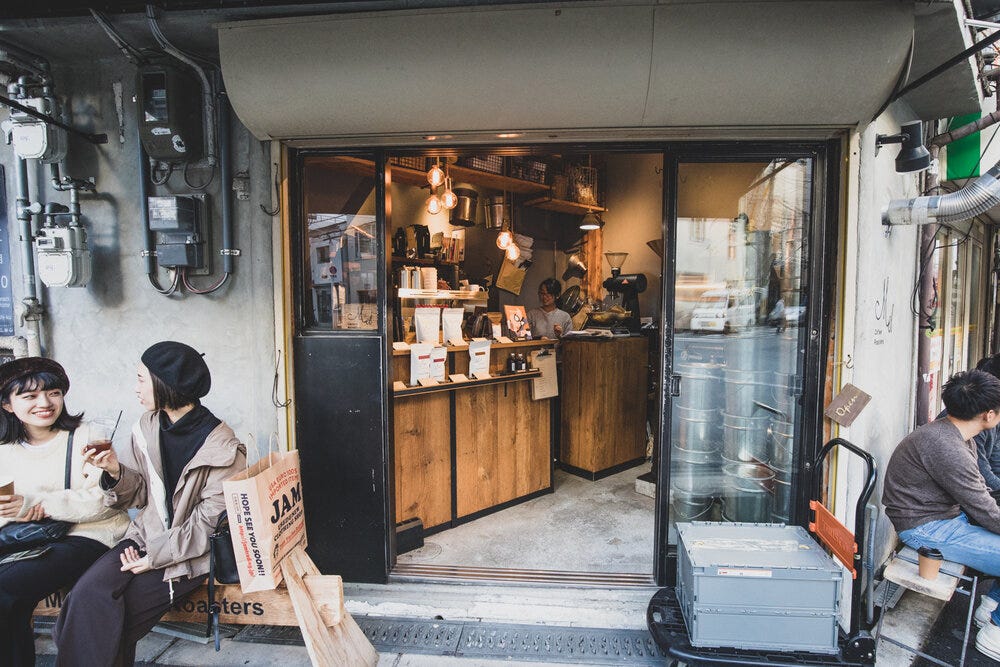 Coffee and smiles in front of Mel Coffee Roasters in Osaka, Japan.