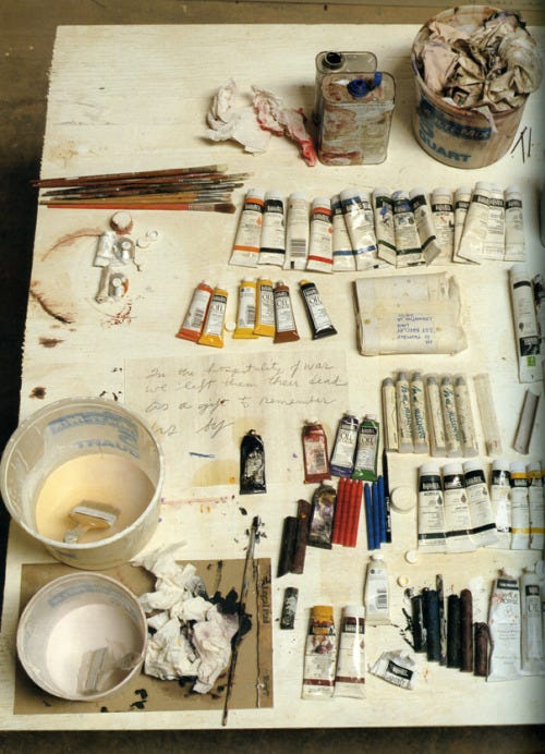 cy twombly's workdesk, full of paint, paintbrushes, and other art materials. it's a great photo