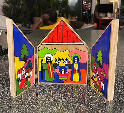 Three panel nativity scene with bright colors standing on its own on a countertop.
