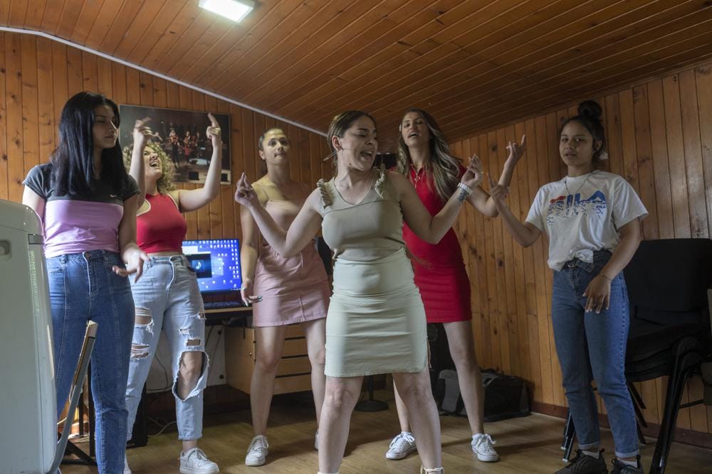 Zlata Ristic, 27, center, Elma Dalipi, 14, left, Silvia Sinani, 24, 2nd left, Dijana Ferhatovic, 18, 3rd left, Zivka Ferhatovic, 20, 2nd right, and Selma Dalipi, 14, members of the Pretty Loud band, practice at a music studio in Belgrade, Serbia, Wednesday, June 16, 2021. A female Roma, or Gypsy, band in Serbia has used music to preach women's empowerment within their community. Formed in 2014, “Pretty Loud” symbolically seeks to give a louder voice to Roma girls, encourage education and steer them away from the widespread custom of early marriage. (AP Photo/Marko Drobnjakovic)
