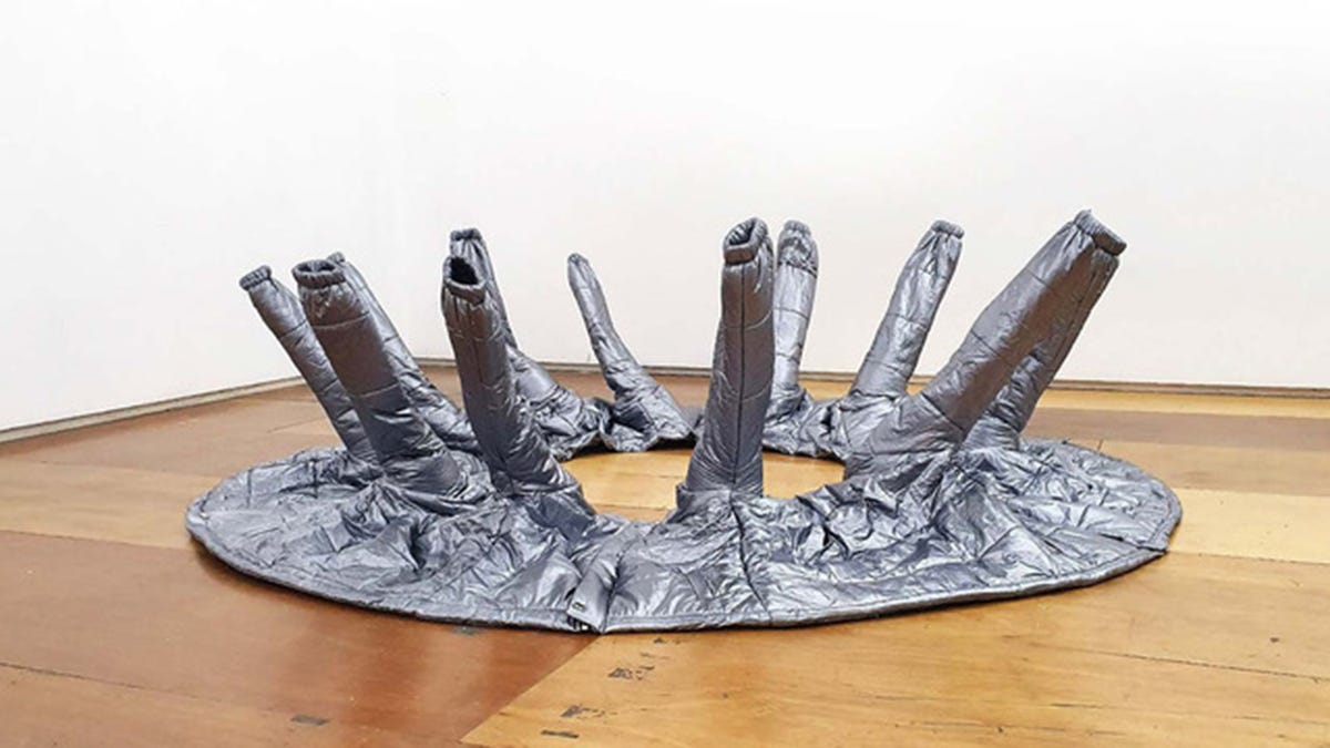 A large, abstract sculpture made from silver puffer jackets.